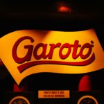 Illuminated Garoto chocolate logo sign with vibrant red and yellow colors, creating a bold and vivid atmosphere.